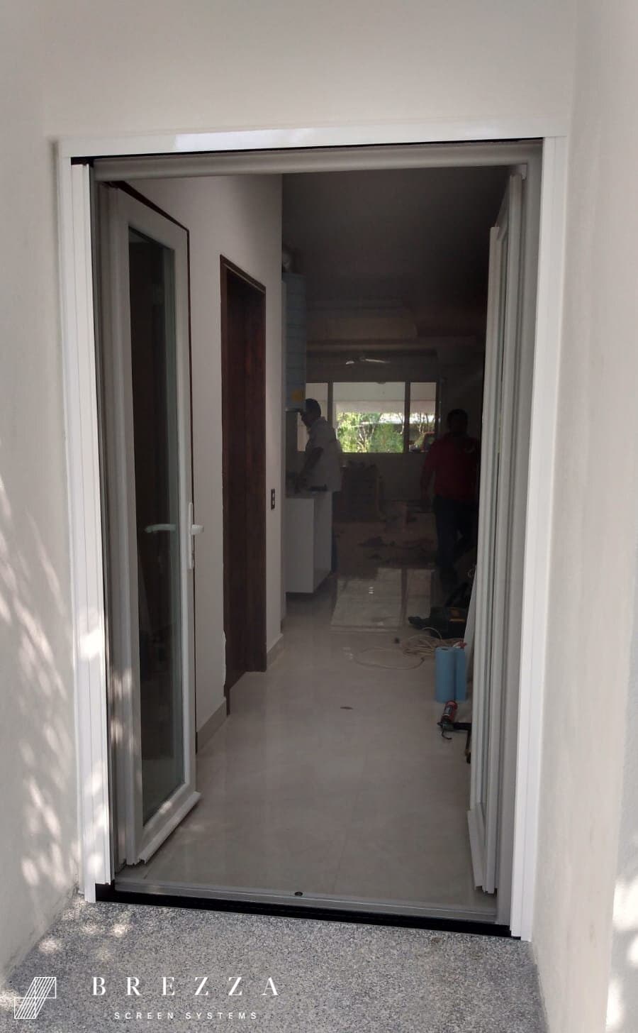 Vista de un mosquitero Brezza blanco con el tipo Astuto en puertas dobles