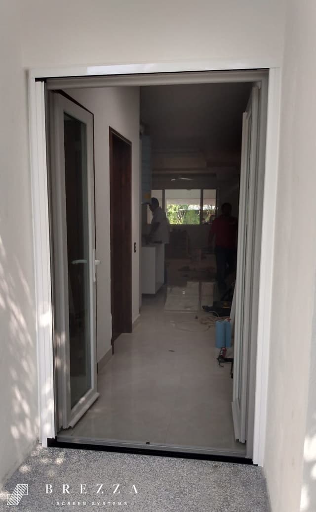 Vista de un mosquitero Brezza blanco con el tipo Astuto en puertas dobles