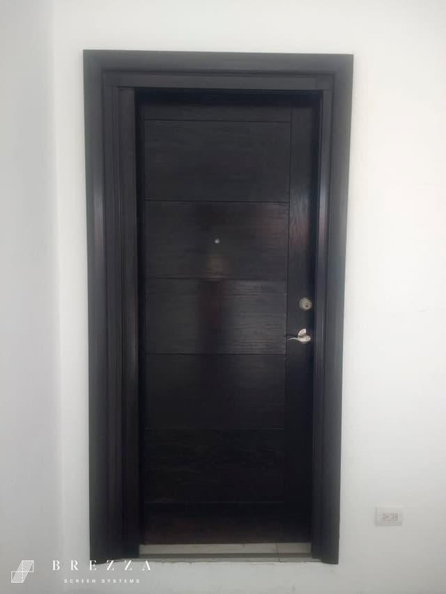 Vista de un mosquitero Brezza negro con el tipo Astuto instalado en una puerta