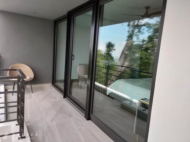 Vista lateral de un mosquitero Brezza marrón con el tipo Astuto instalado en ventanas correderas que están cerradas